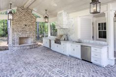 an outdoor kitchen and dining area is shown in this image, with stone flooring