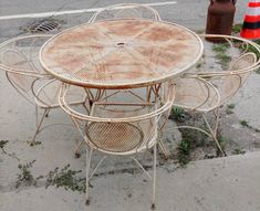 an old table and four chairs sitting on the side of the road in front of a fire hydrant