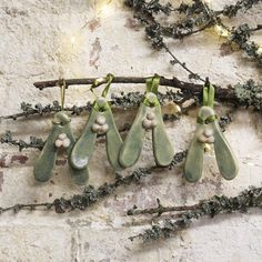 five ceramic hanging plants on a branch