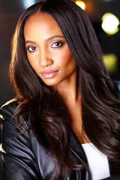 a woman with long brown hair wearing a black leather jacket