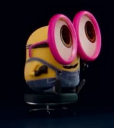 a minion sitting on top of a skateboard with two large eyeballs in it's eyes