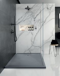 a bathroom with marble walls and flooring, including a walk - in shower area