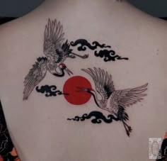 the back of a woman's neck with two birds flying over it and an orange sun