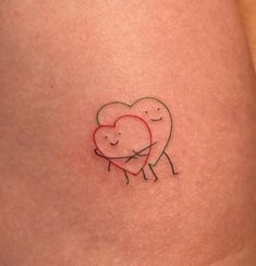 a small heart tattoo on the side of a woman's thigh, with an image of two people hugging each other