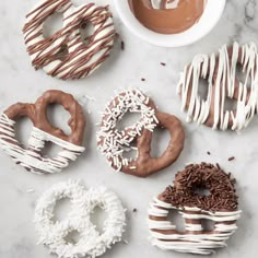 six donuts with chocolate frosting and sprinkles on a marble surface