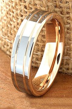 two tone gold and silver wedding ring on a brown cloth with a woven basket in the background