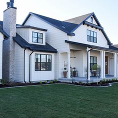 a large white house sitting on top of a lush green field