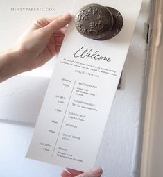 a person holding up a welcome card with a wax seal on it's side