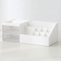 a white box with compartments and dividers on the bottom is sitting on a table