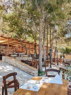 an outdoor dining area with wooden tables and chairs