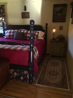 a bedroom with a bed, dresser and rug in the corner next to a window