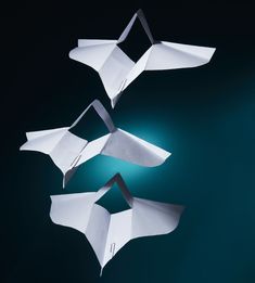 three pieces of white paper are folded in the shape of an origami bird