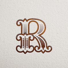 the letter r is made out of wood and has an intricate design on it's side