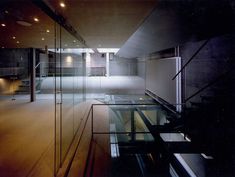 an empty room with glass walls and stairs