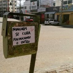 a sign that is on the side of a pole in front of some buildings and cars