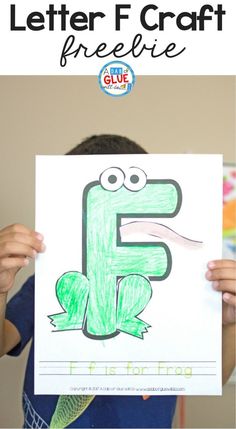 a child holding up a letter f craft with the text, it's for frog