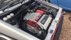 the engine compartment of a car with its hood open and it's batteries still attached