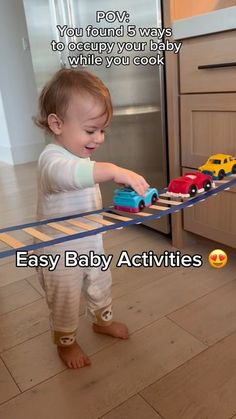 a baby playing with toy cars on a track