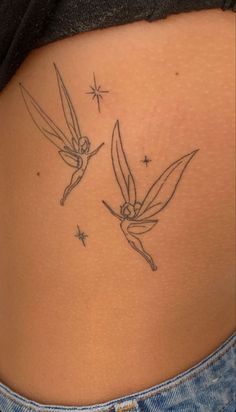 the back of a woman's stomach with two hummings on it and stars in the background