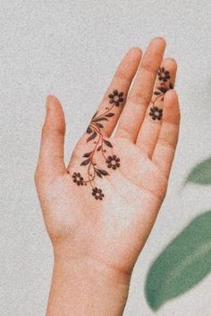 a person's hand with small tattoos on it