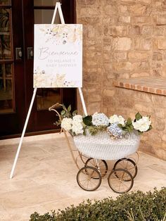 a baby carriage with flowers in front of a sign