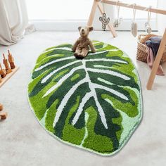 a teddy bear is sitting on a green rug