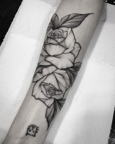 a black and white rose tattoo on the arm