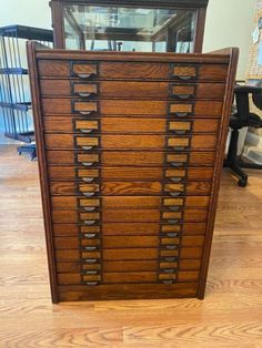 an old wooden cabinet with many drawers on it's sides and a glass top