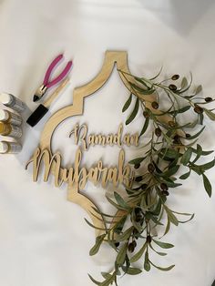 a wooden sign that says rama mubarak next to scissors and olive branches