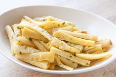 a white bowl filled with pasta on top of a table