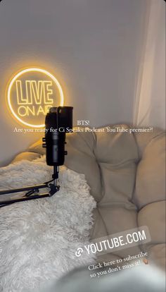 a white couch with a neon sign above it that says, live on air are you ready for your class? please