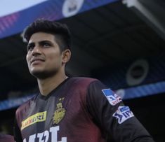 a young man standing in front of a stadium