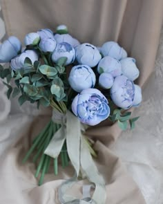 a bouquet of blue flowers sitting on top of a white cloth