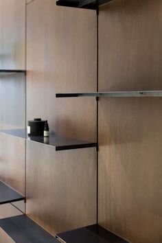 the shelves in this room are made of wood and black metal, with two cups on each shelf