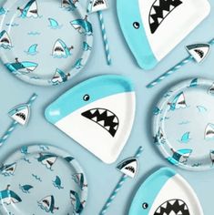 several plates with sharks painted on them and paper straws in the shape of shark's teeth