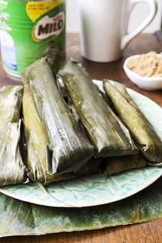 three tamales on a plate next to a can of milk