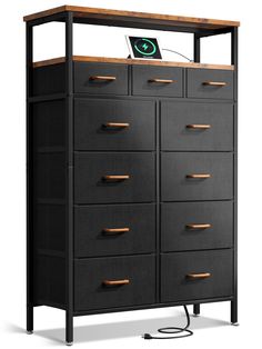 a black dresser with wooden drawers and an electronic device in the top drawer on it