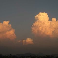 the sky is filled with white clouds as the sun sets