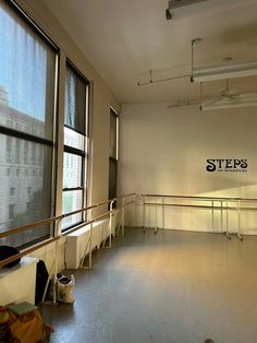 an empty room with windows and railings in front of the window is a sign that reads steps