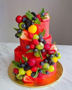 a three tiered cake decorated with fresh fruit