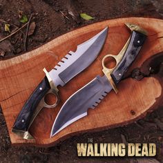 two knives sitting on top of a wooden cutting board with the words the walking dead