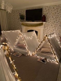 some lights are hanging from the ceiling in a room with a fireplace and bedding