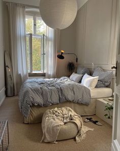 a large bed sitting next to a window in a bedroom on top of a carpeted floor