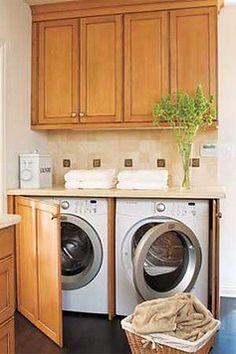 a washer and dryer in a room with wooden cabinets