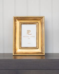 a gold frame sitting on top of a wooden table