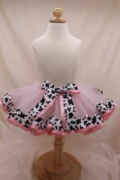 a mannequin wearing a pink and black cow print tutu skirt