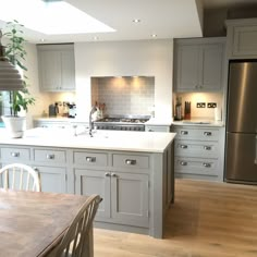 a large kitchen with an island, stove and refrigerator freezer next to a dining room table