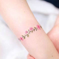 a woman's arm with pink flowers on it