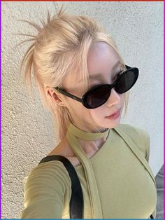 a blonde woman wearing sunglasses and a black leather shoulder bag is posing for the camera