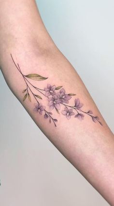 a woman's arm with purple flowers on it